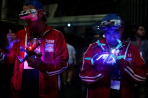 Pilots holding lit drones