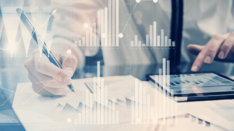 A person uses a tablet to plot financial charts.