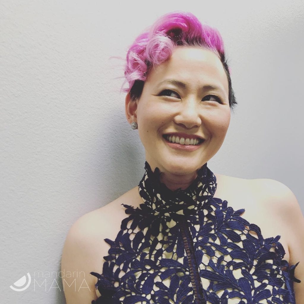 woman with pink hair smiling