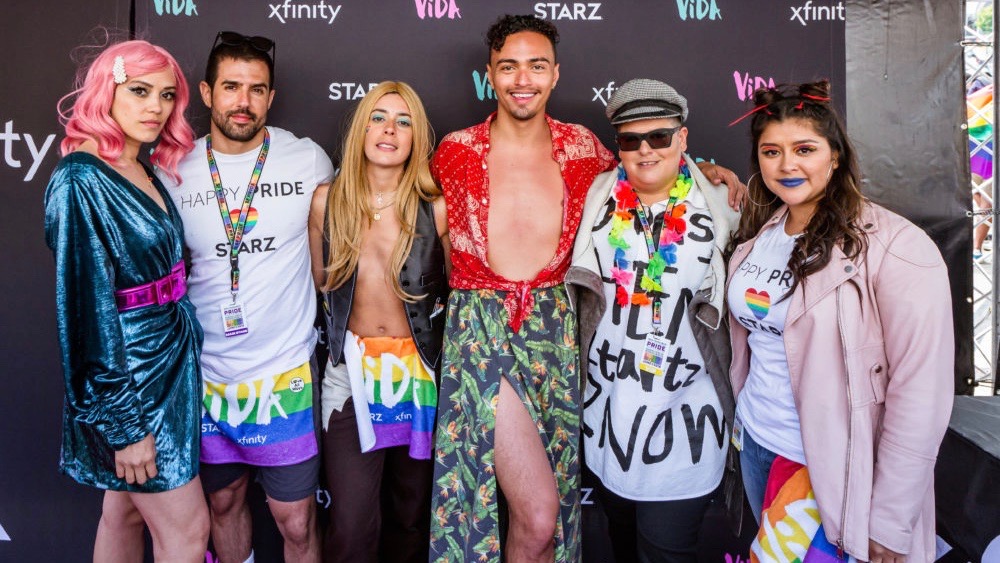 San Francisco Pride Parade participants stand next to each other and smile.