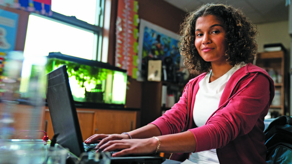 A teenager uses her laptop.