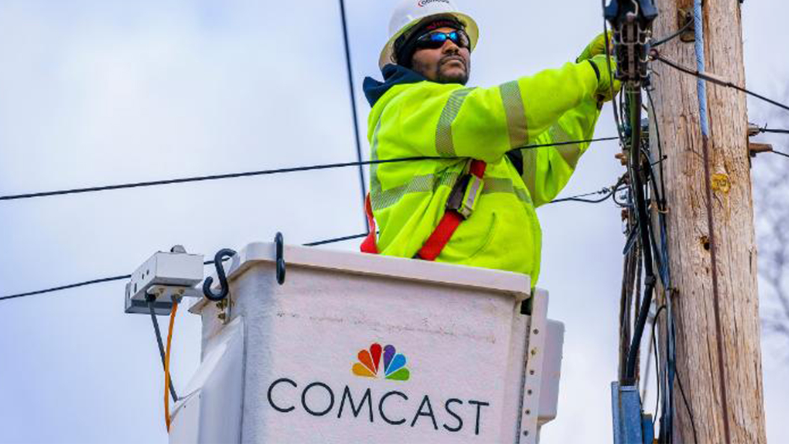 A Comcast technician services a telephone pole.