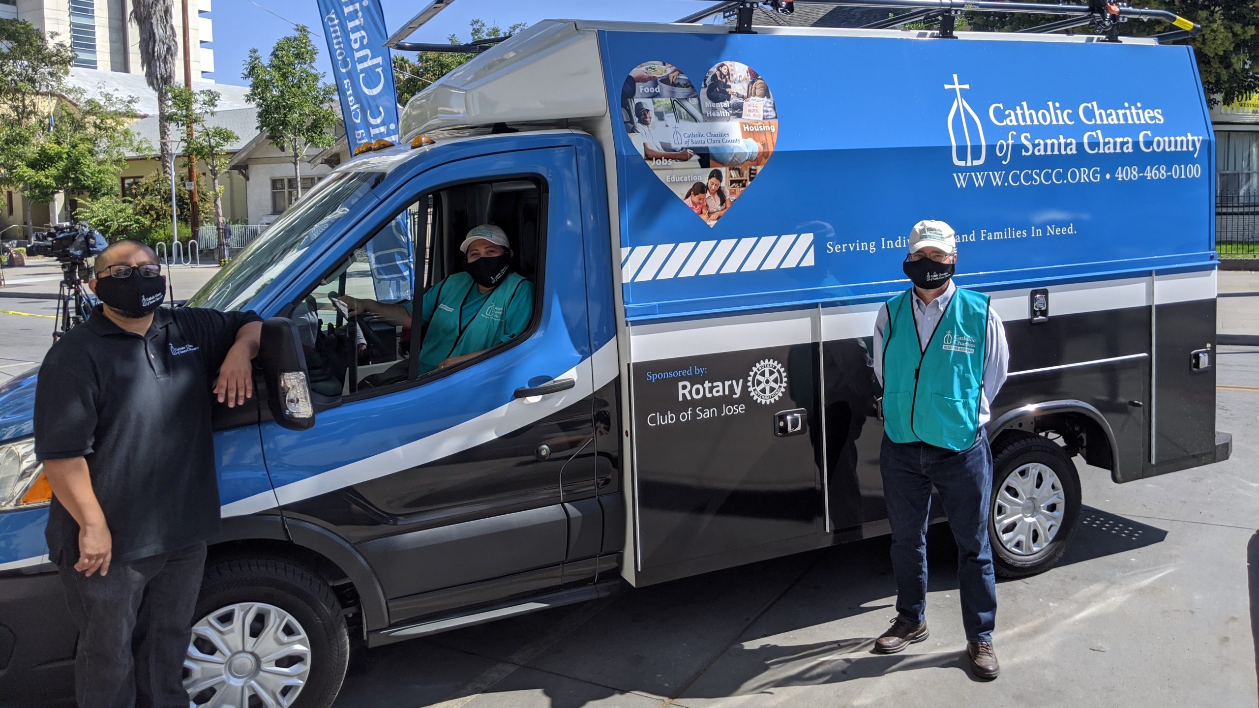 Volunteers in front of a Catholic Charities of Santa Clara County van