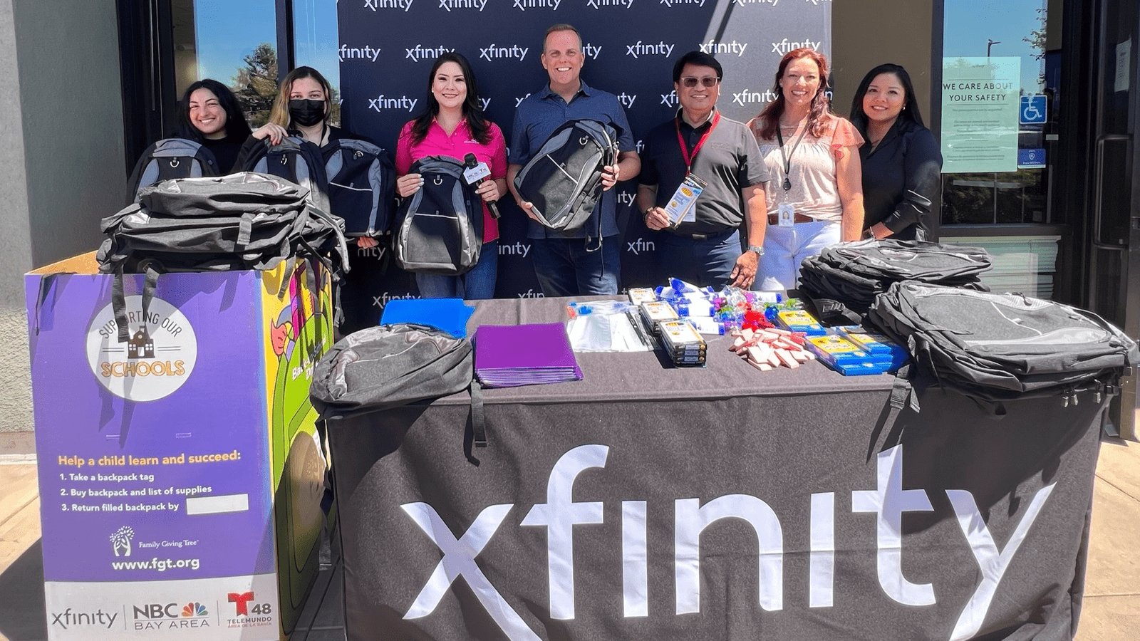 Volunteers giving away backpacks at a Family Giving Tree’s Backpack Drive event.