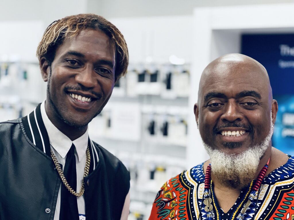 Two guests smile and stand together for a photo at the Oakland Metro Chamber mixer at the Xfinity store on Broadway in Oakland, CA