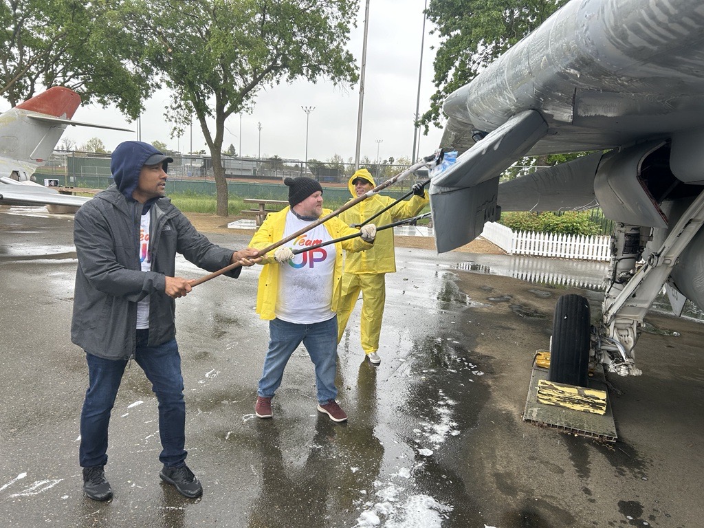 Comcast employees volunteer and wash aircrafts at the Aerospace Museum of California